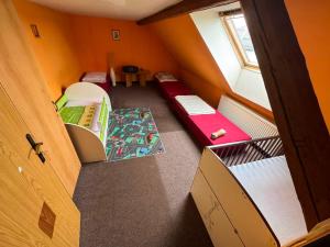 an attic room with two beds and a window at Penzion Nord in Hora Svatého Šebestiána +9 photos