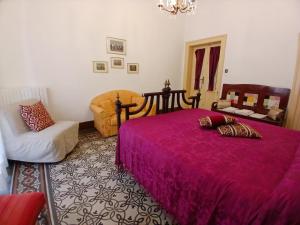 a bedroom with a pink bed and a chair at Guesthouse City Center in Bari +121 photos