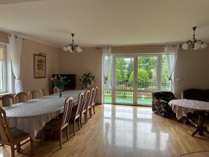 a dining room with a long table and chairs at Willa nad stawem in Mezowo