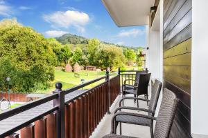 a balcony with chairs and a view of a park at Nord Hotel in Borşa