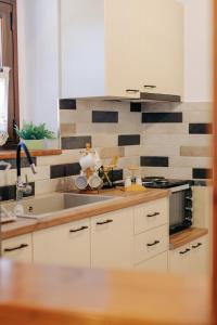 a kitchen with white cabinets and a sink at Rustic Kampos House Retreat in Chios +18 photos