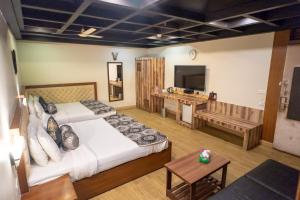 a hotel room with two beds and a television at The Nagpur Ashok in Nagpur