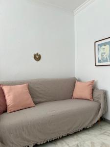 a couch in a living room with pink pillows at Casa Quijote in La Herradura