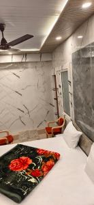 a bedroom with a bed with a flower blanket on it at Hotel Siddhant in Pithorāgarh