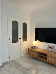 a living room with a tv and a table and a door at Casa Quijote in La Herradura