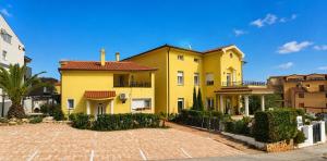 a yellow house with a fence in front of it at Villa Istriana in Ližnjan