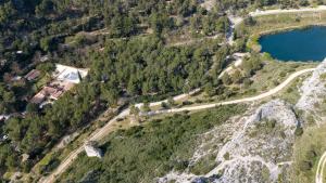 an aerial view of a mountain with a road and a lake at Camping de la Vallée Heureuse in Orgon