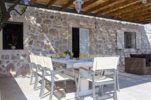 a table and chairs on a patio with a stone wall at Hedera Estate, Villa Hedera VIII in Orasac