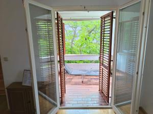 an open door to a porch with a bench outside at Pine Breeze in Punat
