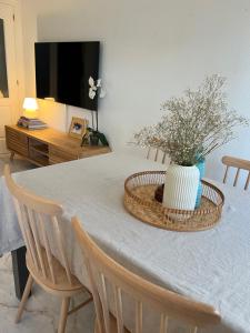 a dining room table with a vase of flowers on it at Casa Quijote in La Herradura