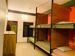 a room with three bunk beds and a kitchen at Laughing Leopard Trinco in Trincomalee