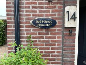 a sign on the side of a brick building at Bed en Brood Prunushof in Zelhem