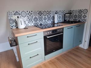 a kitchen with blue cabinets and a stove top oven at Ferienwohnung Hof Dittmer in Bleckede