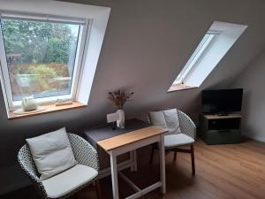 a living room with a table and chairs and windows at Ferienwohnung Hof Dittmer in Bleckede