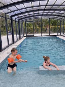 a boy and a girl in a swimming pool at Villa Marcus in Rowy