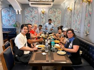 a group of people sitting around a table in a restaurant at Ray of Maya near to taj mahal in Agra