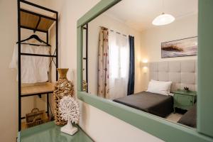 a small bedroom with a bed and a mirror at Roys Blu in Kavos