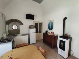a kitchen with a table and a kitchen with white appliances at Appartamento in Corte Storica in Alzano Lombardo