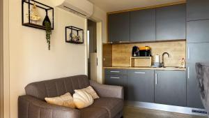 a living room with a couch and a kitchen at Mobile Home SkyLine - beautiful sea view - on the palm of the beach in Drage
