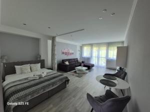 a bedroom with a bed and a table and chairs at Park Apartman in Kaposvár