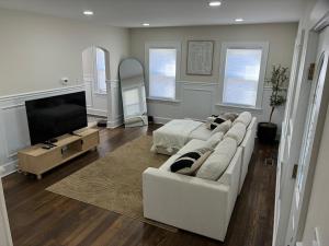 a living room with a white couch and a flat screen tv at The Signature Stay in Clifton