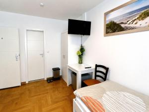 a bedroom with a bed and a desk with a computer at Stendaler Apartments in Stendal