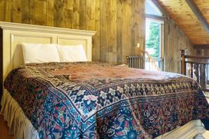 a bedroom with a bed in a room with wooden walls at 468 Pequawket Drive in Conway