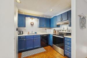 a blue kitchen with blue cabinets and a sink at 2D Village at North Conway in Conway
