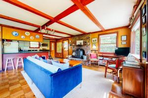 a living room with a blue couch and a kitchen at Notch Lodge in Franconia