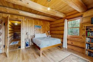 a bedroom with a bed in a log cabin at Eaglet Log Home in Franconia