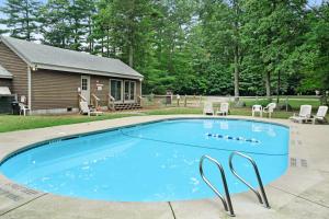 a swimming pool in a yard with a house at North Conway Townhouse 3H in North Conway