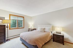 a bedroom with a bed with two lamps and a window at North Conway Townhouse 3H in North Conway +61 photos