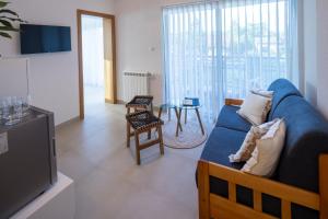 a living room with a blue couch and a table at Artemis Escape Suites Srebrno Jezero in Veliko Gradište