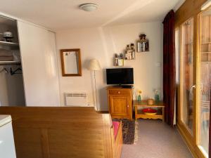 a living room with a television and a table with a tv at Appartement avec balcon 6 personnes Superdévoluy in Le Dévoluy