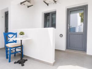 a table and a blue chair next to a door at Nest & Rest Perissa in Perissa