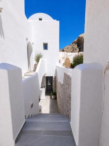 a hallway with white buildings and a blue sky at Nest & Rest Perissa in Perissa