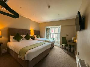 a hotel room with two beds and a desk at Adams Townhouse in Dingle