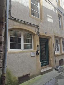 a building with a green door on a street at Appartement cocooning Sierck-les-Bains in Sierck-les-Bains