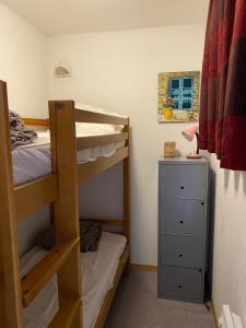 a bedroom with two bunk beds and a dresser at Appartement avec balcon 6 personnes Superdévoluy in Le Dévoluy
