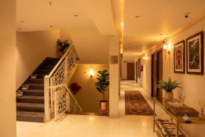 a hallway of a house with stairs and plants at Hotel Madhuram Shivpuri MP in Shivpurī