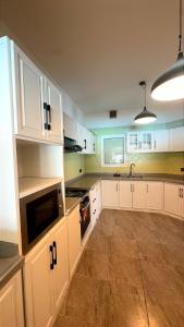 a kitchen with white cabinets and a stove top oven at شالية البردايس درة العروس من ارقى الشاليهات in Durat Alarous