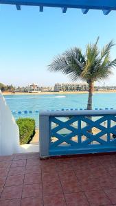 a blue fence with a palm tree in front of the water at شالية البردايس درة العروس من ارقى الشاليهات in Durat Alarous