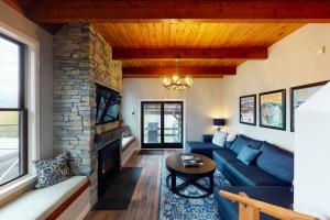a living room with a blue couch and a stone fireplace at New England Treasure in North Conway