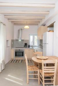 a kitchen with a table and a refrigerator at Xenia Xinara in Tinos +17 photos