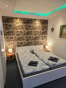 a bedroom with a bed and a brick wall at Gästehaus an der Bode wahlweise mit Halbpension PLUS in Braunlage +125 photos