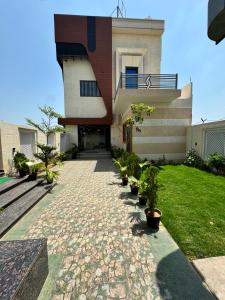 a house with a stone walkway in front of it at Atmosphere Hotel & Restaurant in Alīgarh