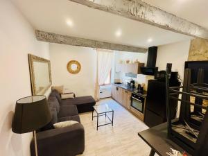 a living room with a couch and a kitchen at Appartement T2 centre village in Cucuron