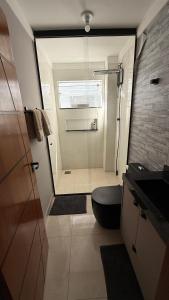 a small bathroom with a toilet and a shower at Apartamento 2 quartos com ar-condicionado, Wi-Fi e Netflix in Americana