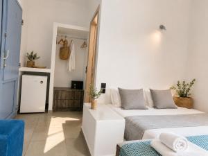 a bedroom with two beds and a blue chair at Nest & Rest Perissa in Perissa