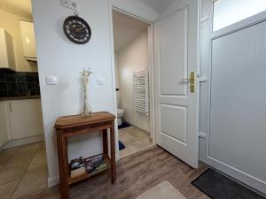 a room with a door and a table with a clock on the wall at Studio moderne climatisé - Parking gratuit - Paris & Disney in Ormesson-sur-Marne